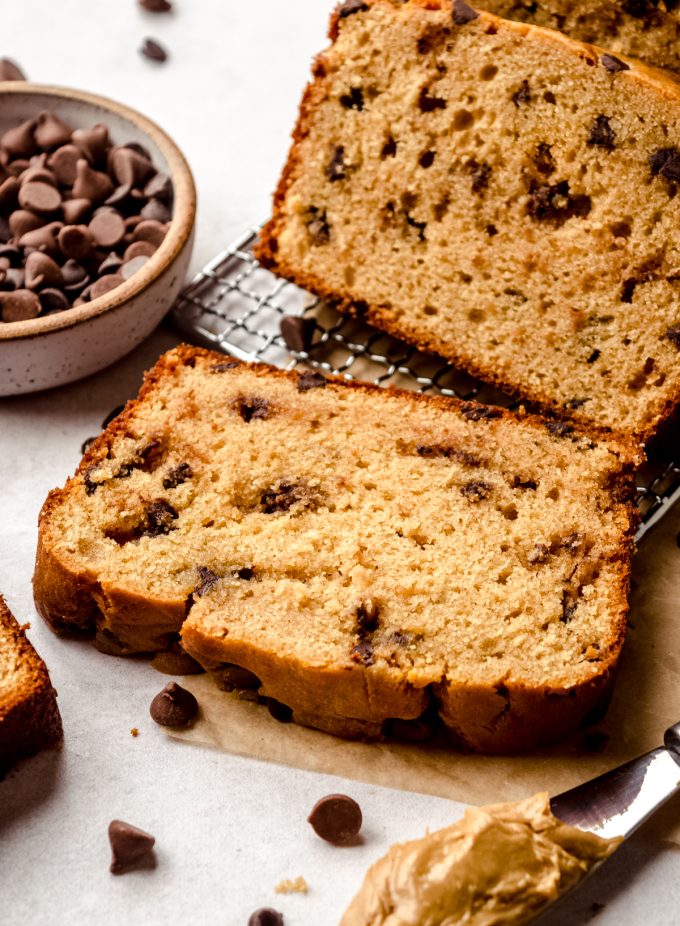 A slice of chocolate chip peanut butter bread on a wire cooling rack.