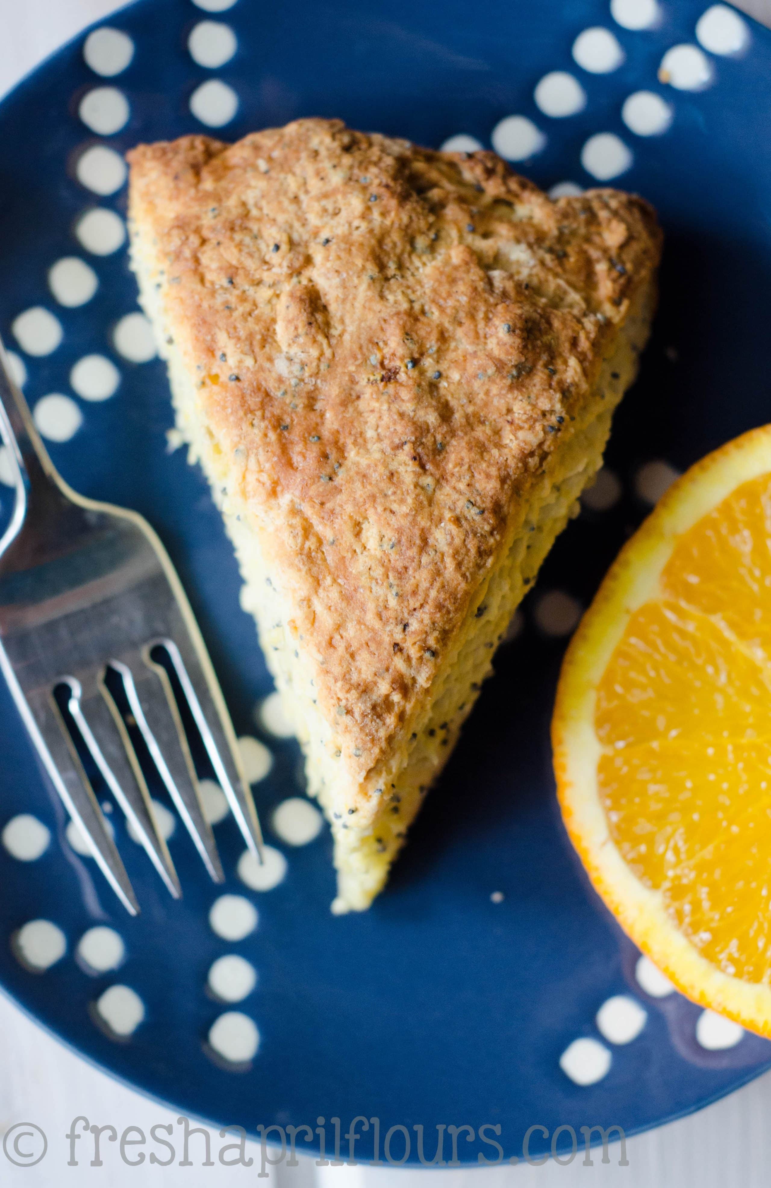 orange poppy seed scone on a plate with a fork