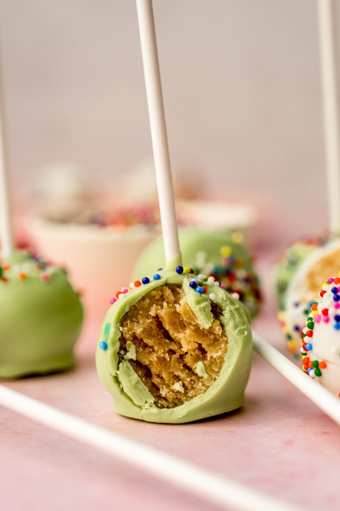 A cake pop with a bite taken out of it.