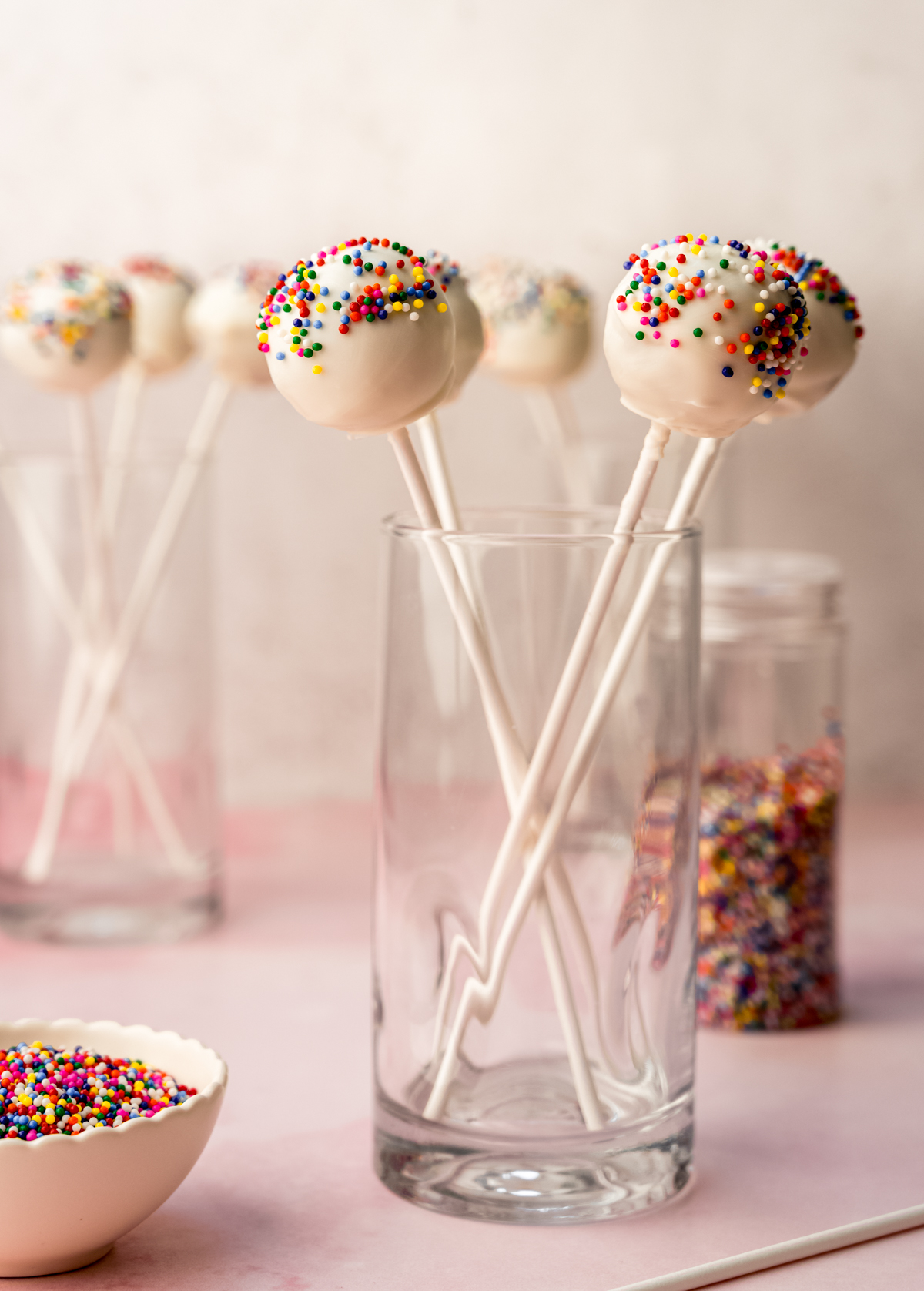 Cake pops in a tall glass cup so they can dry.