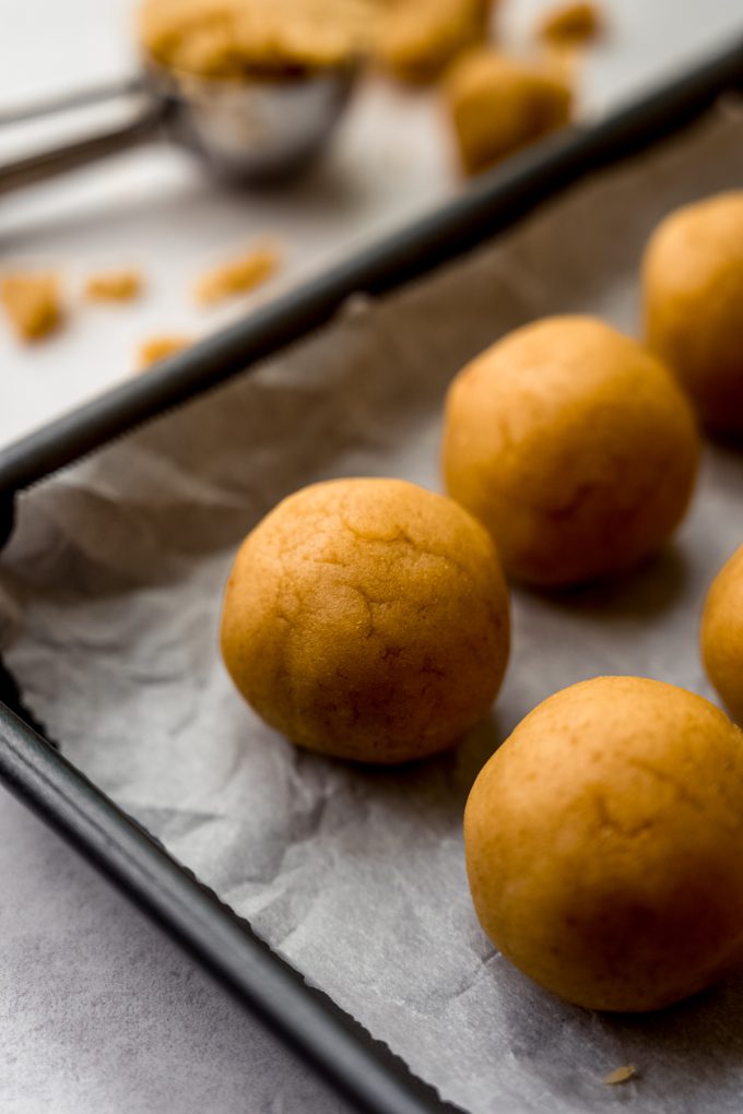 Cake pop balls on a baking sheet.