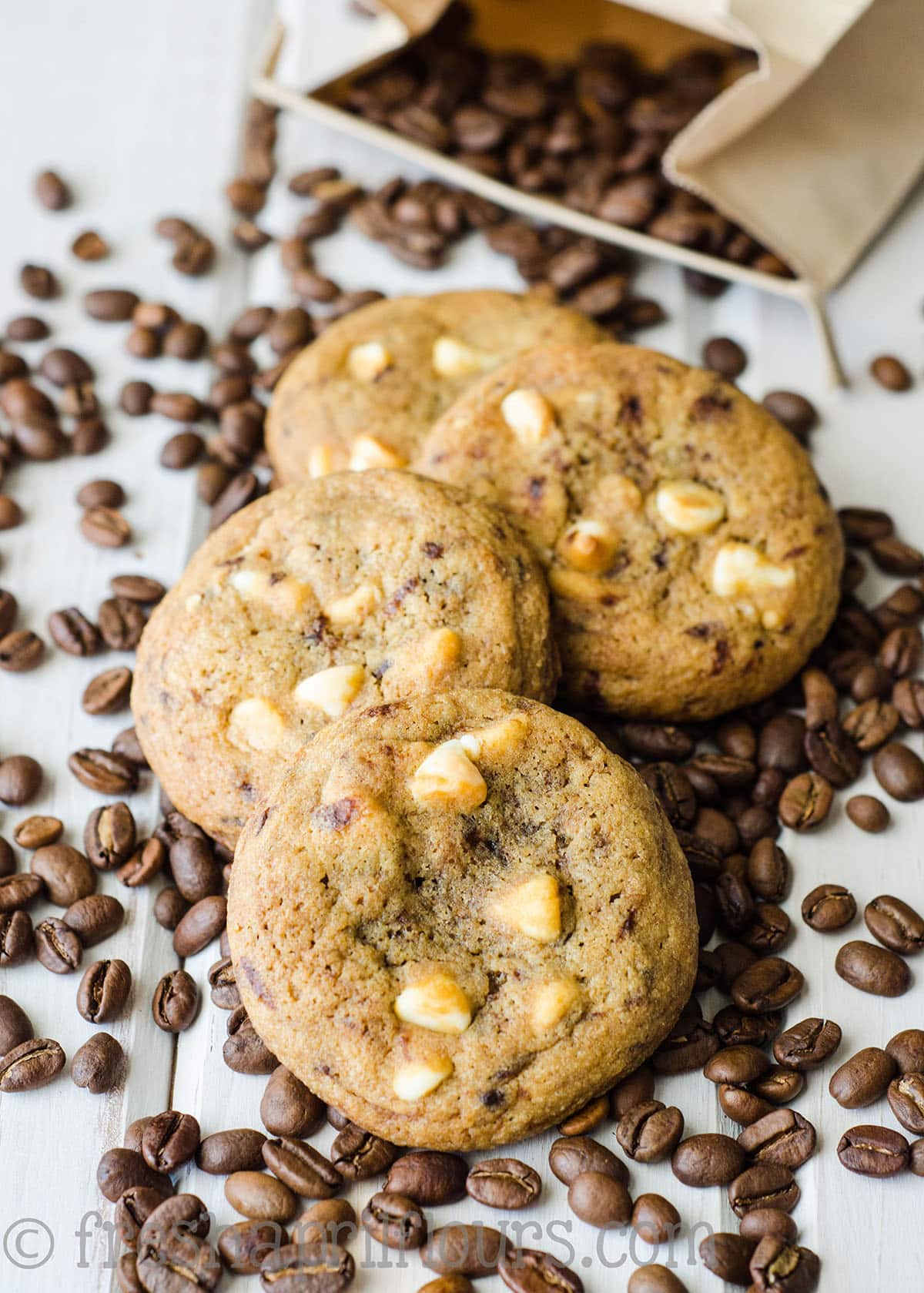 a stack of cappuccino cookies spread out on coffee beans