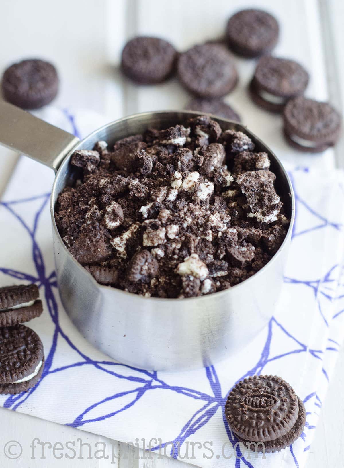 A measuring cup full of crushed Oreos.