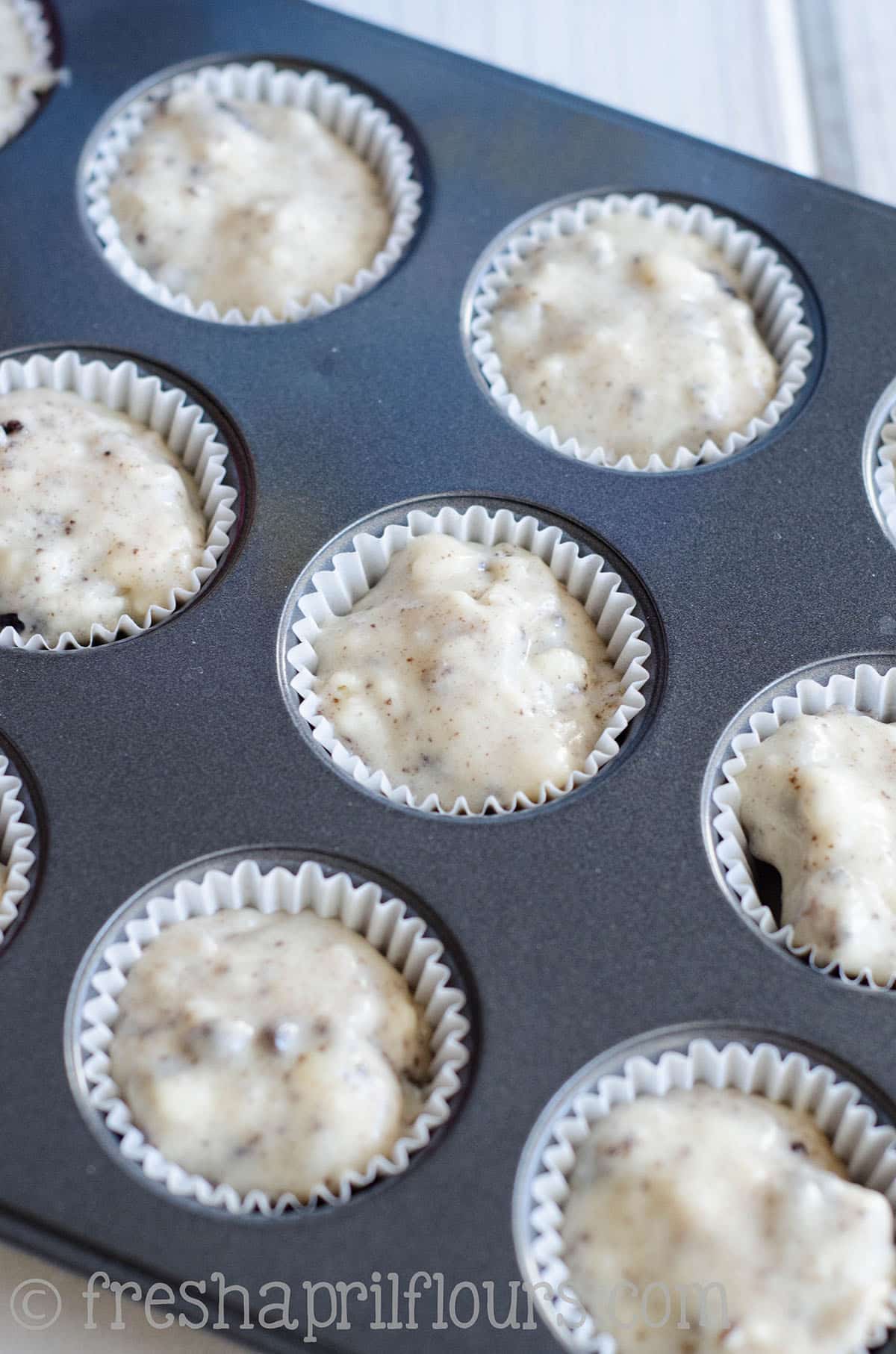 Mini cookies and cream cupcake batter in a mini cupcake pan.