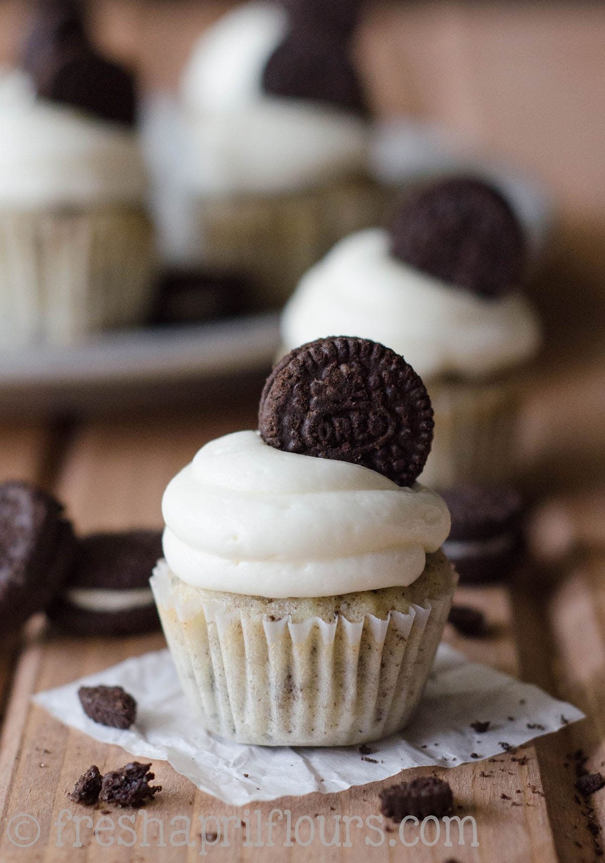 Mini cookies and cream cupcake on a piece of parchment.