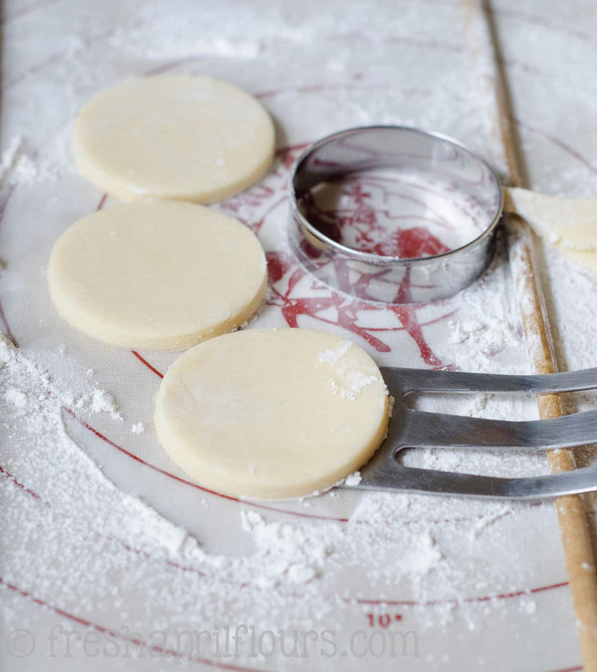 transferring cut-out cookies from the rolling surface with a spatula