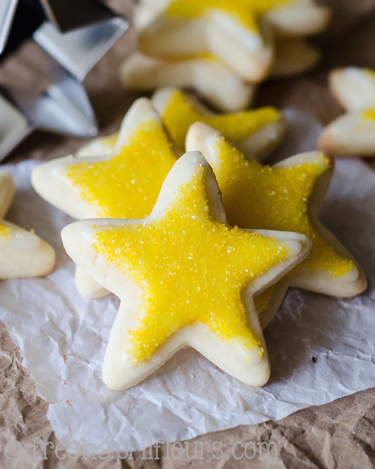 cut out sugar cookies in the shapes of stars with yellow sprinkles