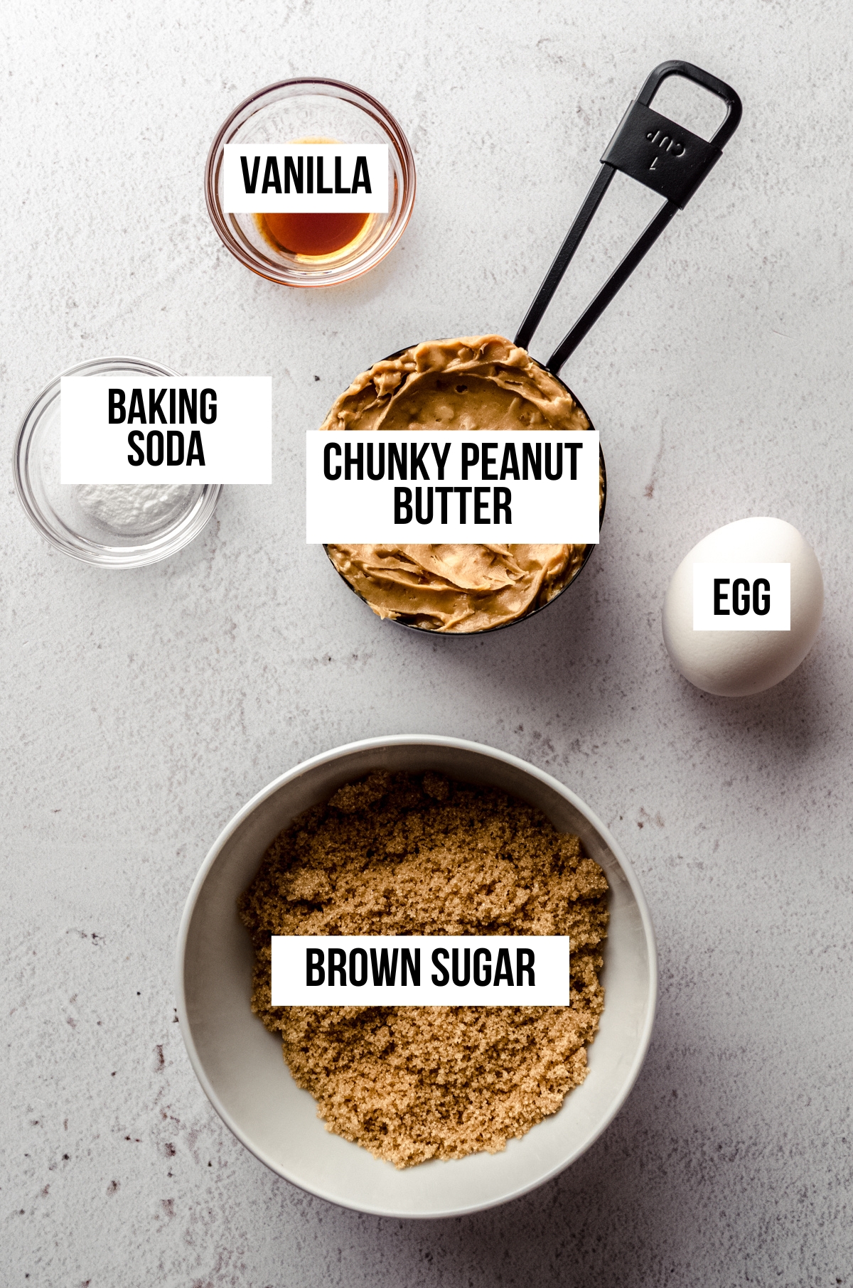 Aerial photo of ingredients to make flourless peanut butter cookies with text overlay labeling each ingredient.