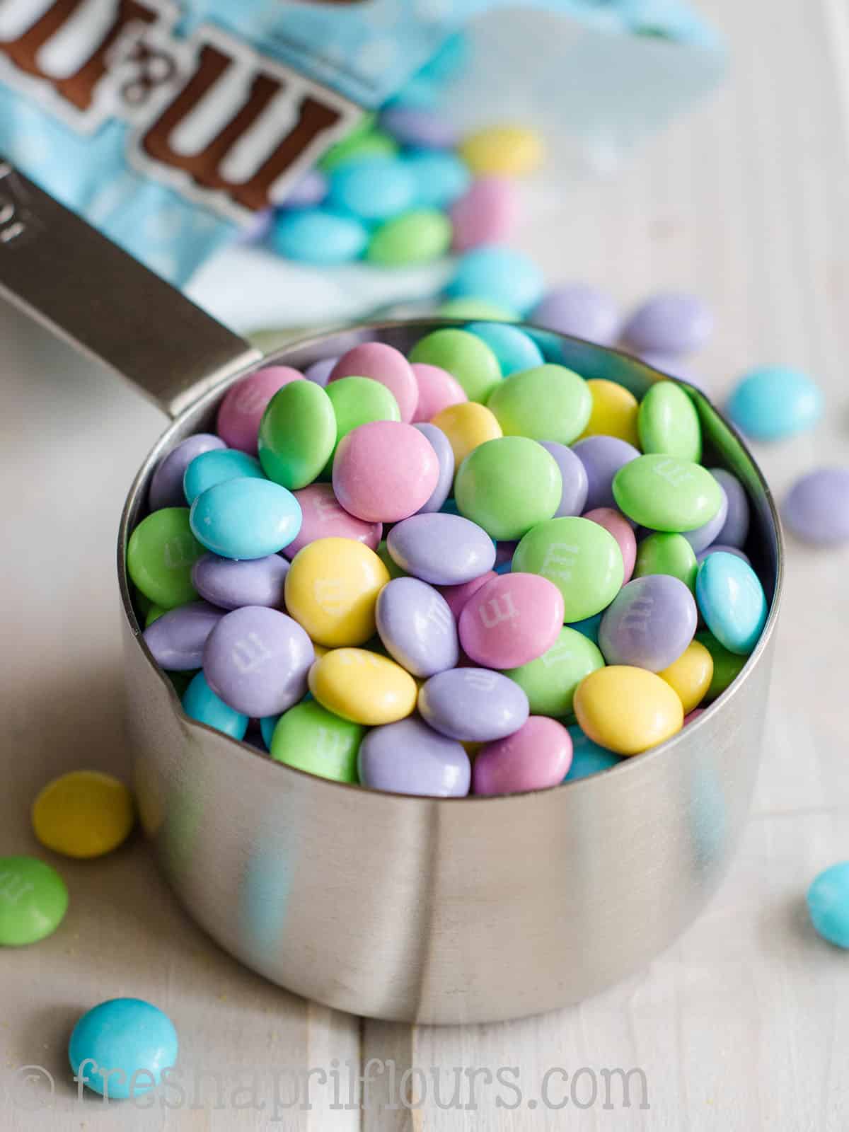 Easter m&ms in a measuring cup.