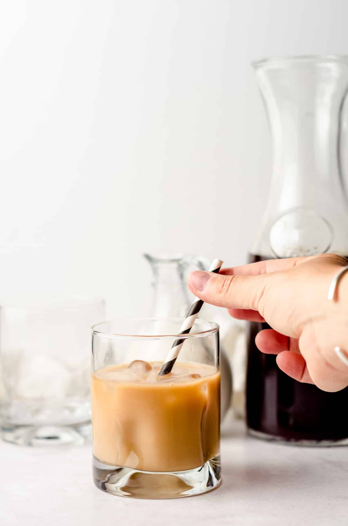 putting a straw into a glass of cold brew coffee