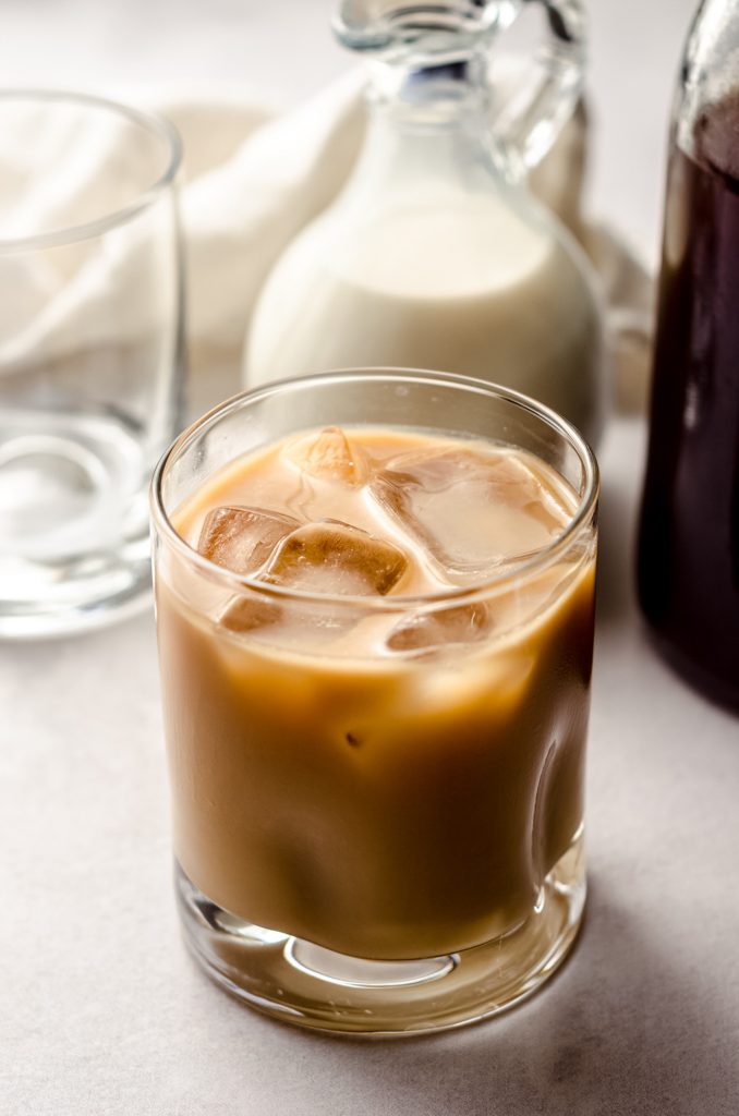 a glass of cold brew coffee with cream and ice cubes