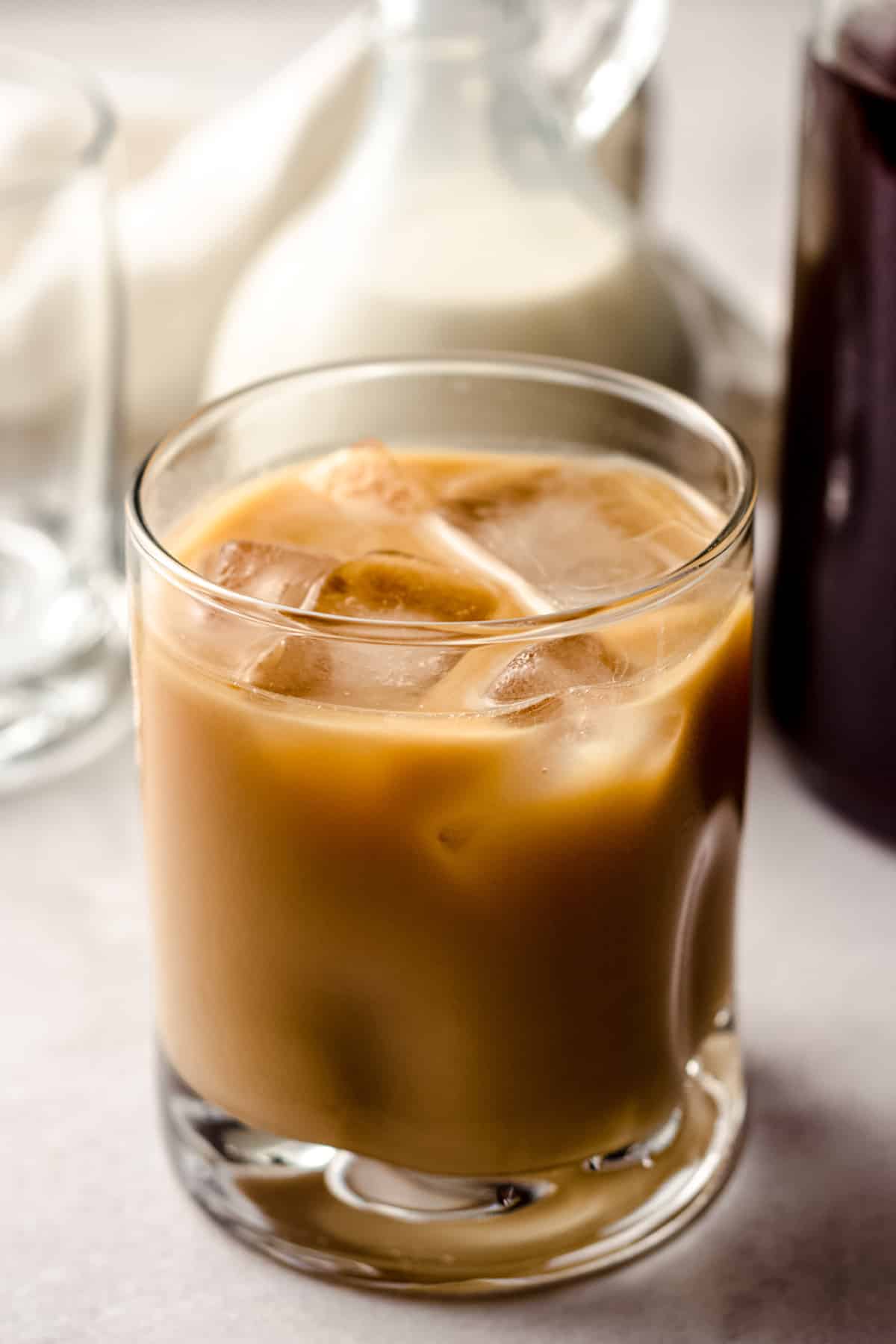 a glass of cold brew coffee with cream and ice cubes