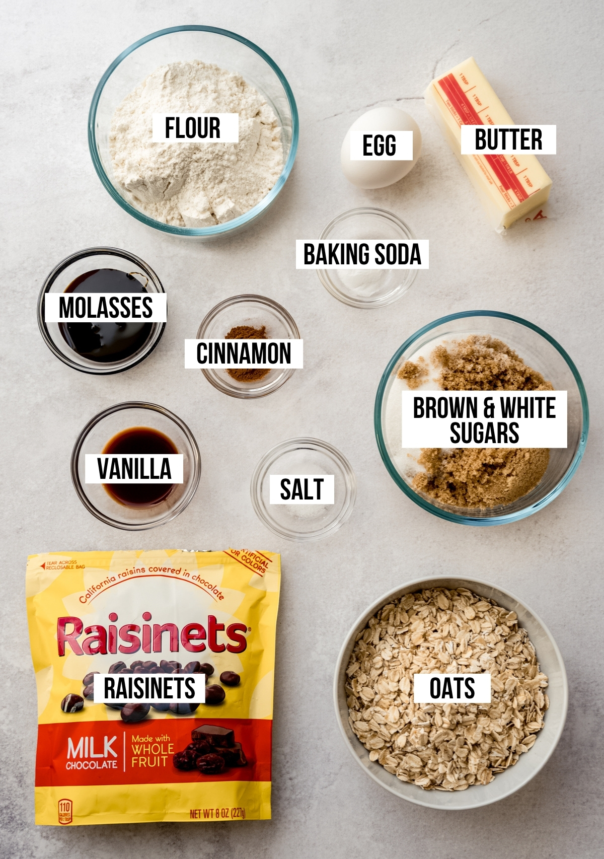 Aerial photo of ingredients to make oatmeal Raisinet cookies with text overlay labeling each ingredient.