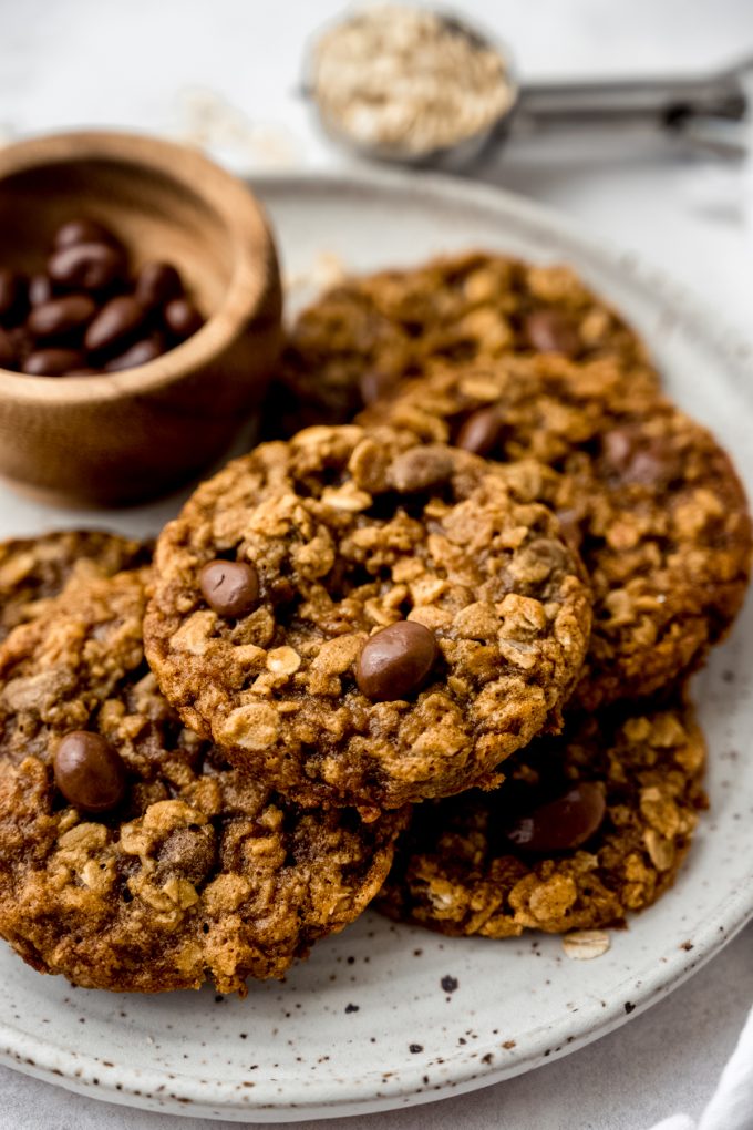 Oatmeal Raisinet cookies on a plate with a small bowl of Raisinets on the plate, too.