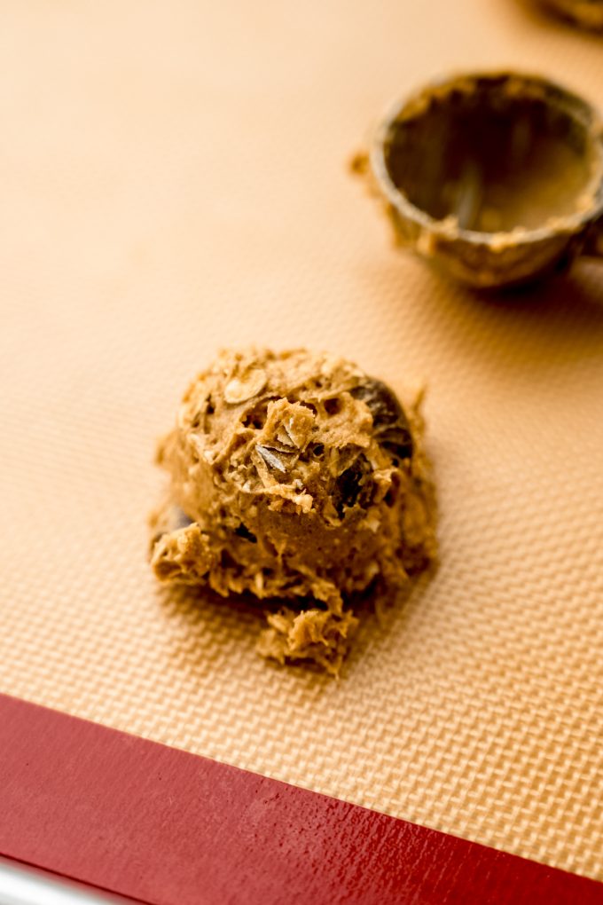 A ball of oatmeal Raisinet cookie dough on a baking sheet.