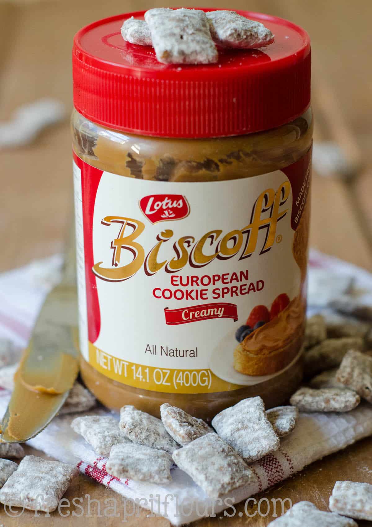 A jar of Biscoff with Biscoff puppy chow on top and around it.