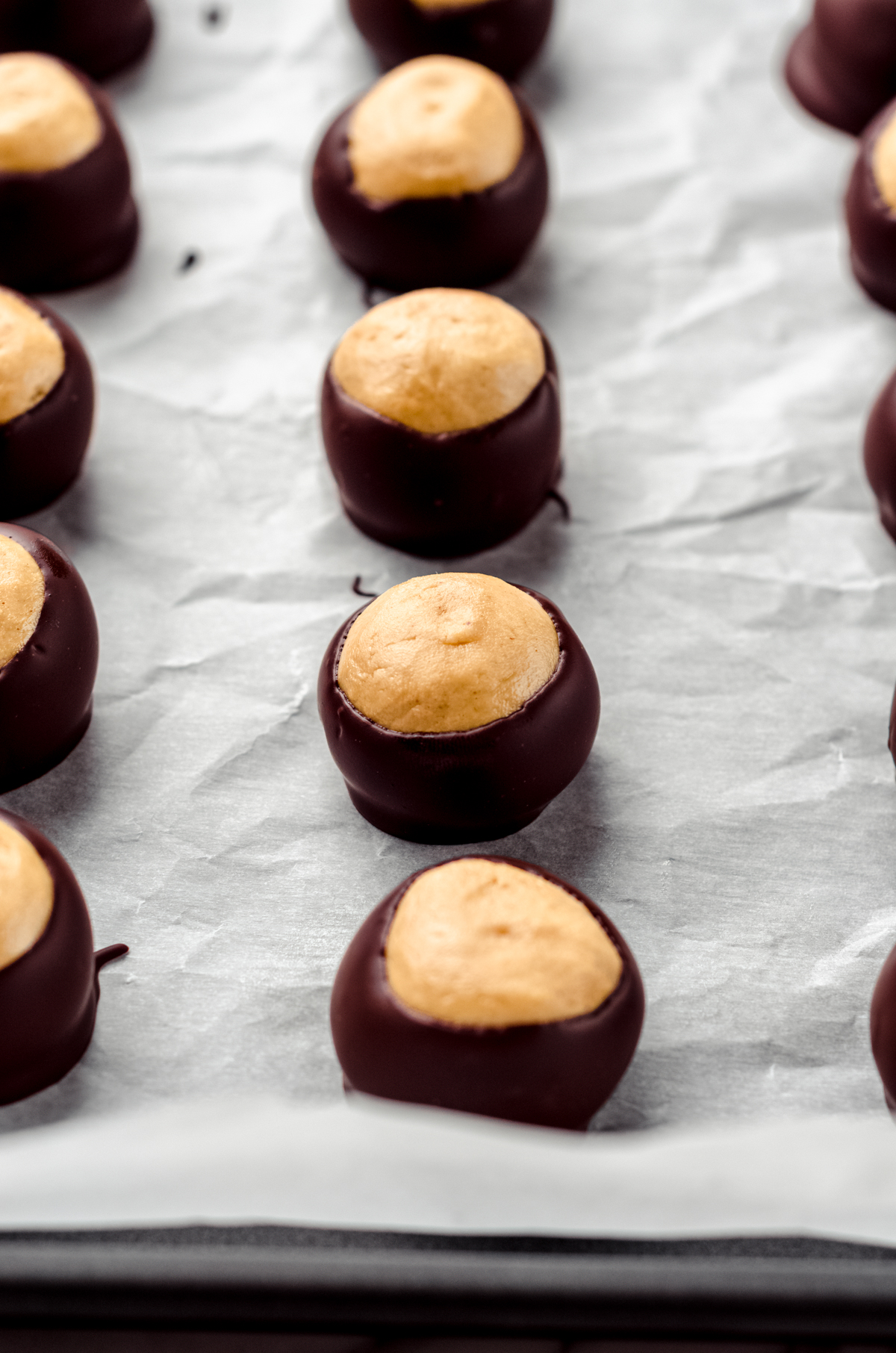 Buckeye balls on a baking sheet lined with parchment.