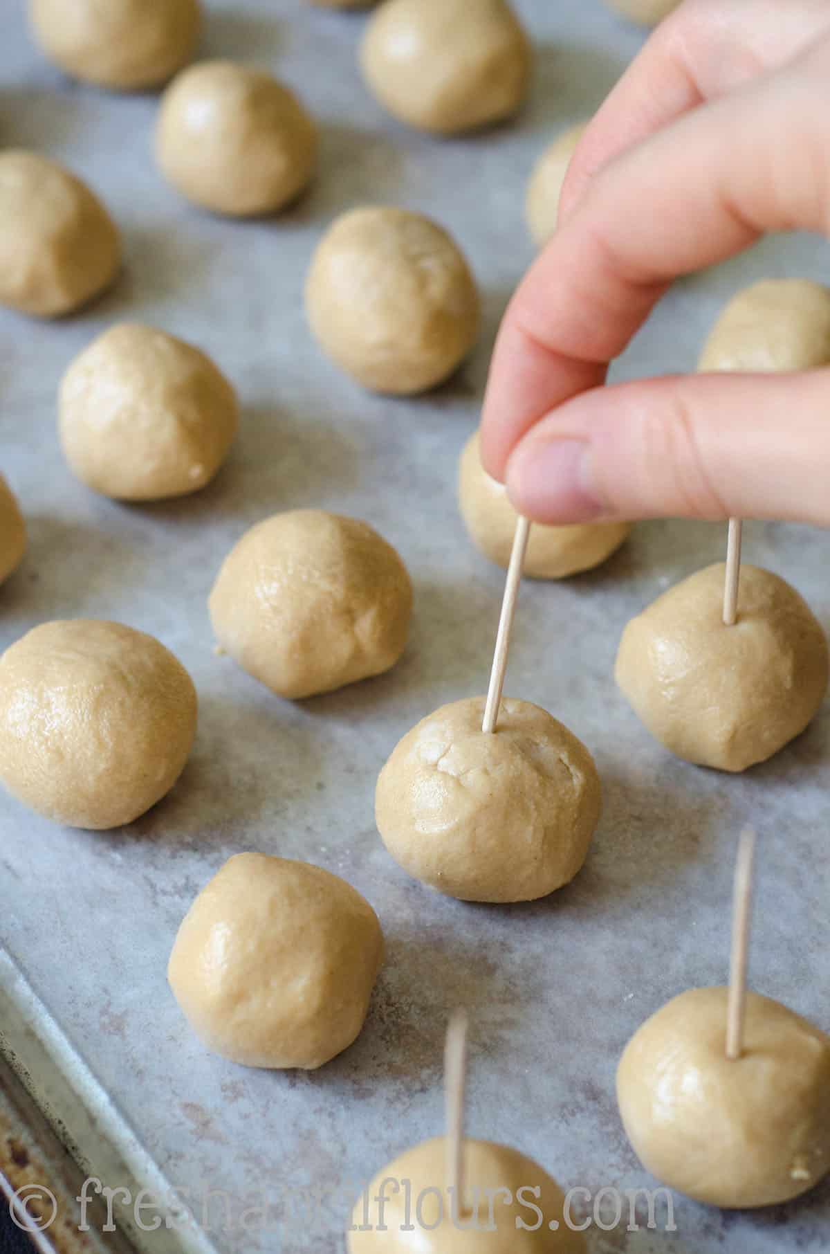 putting a toothpick into buckeye candy peanut butter filling