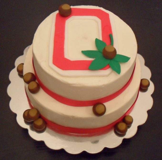 An Ohio State grooms cake with the Ohio State logo and buckeyes made from fondant.