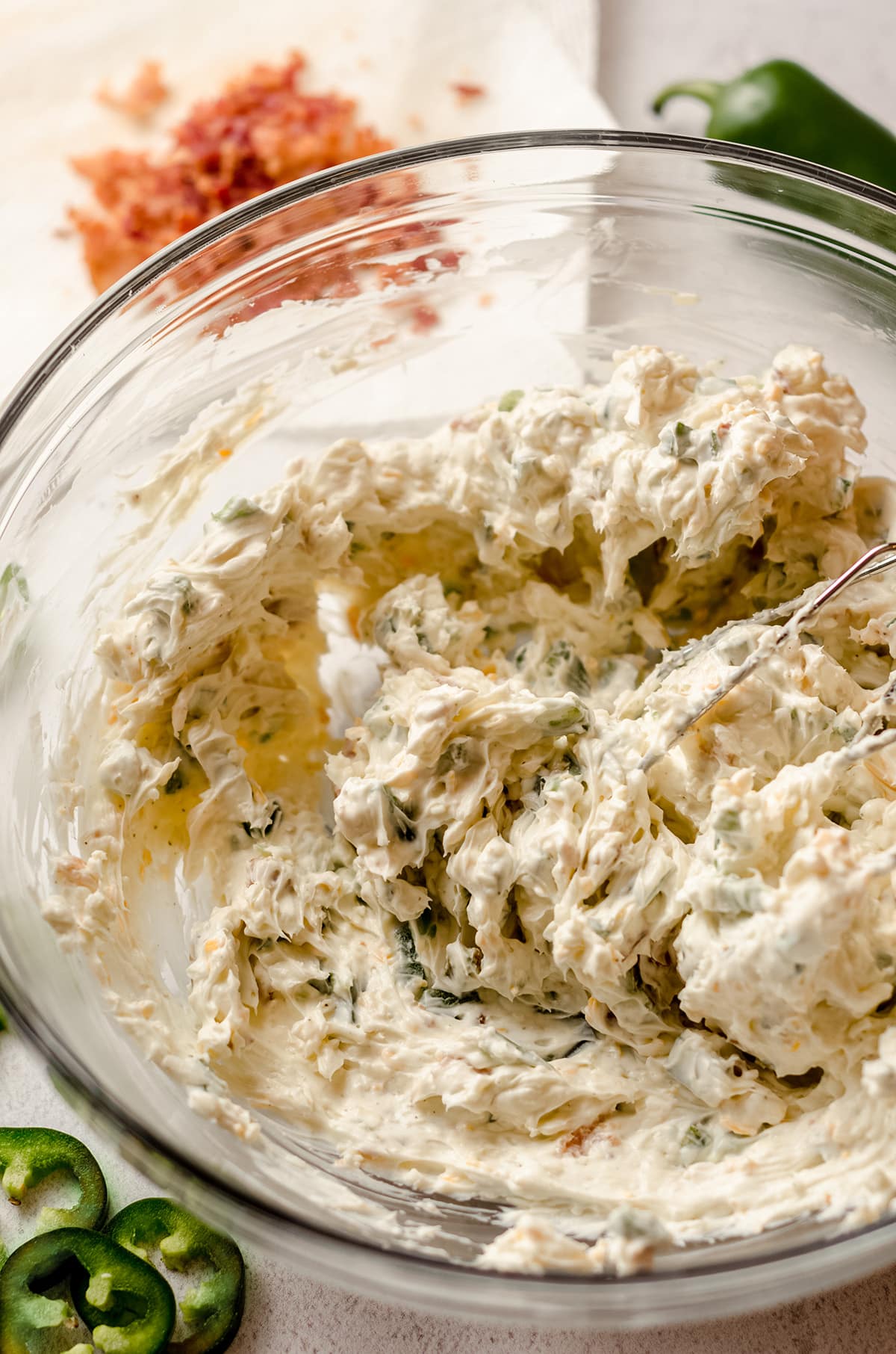 jalapeno cream cheese dip in a glass bowl with beaters