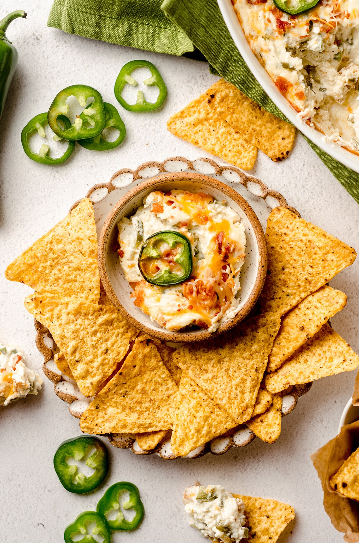 aerial photo of jalapeno cream cheese dip in a bowl on a plate with chips