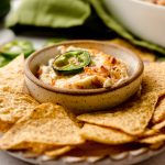 jalapeno cream cheese dip in a bowl on a plate with chips