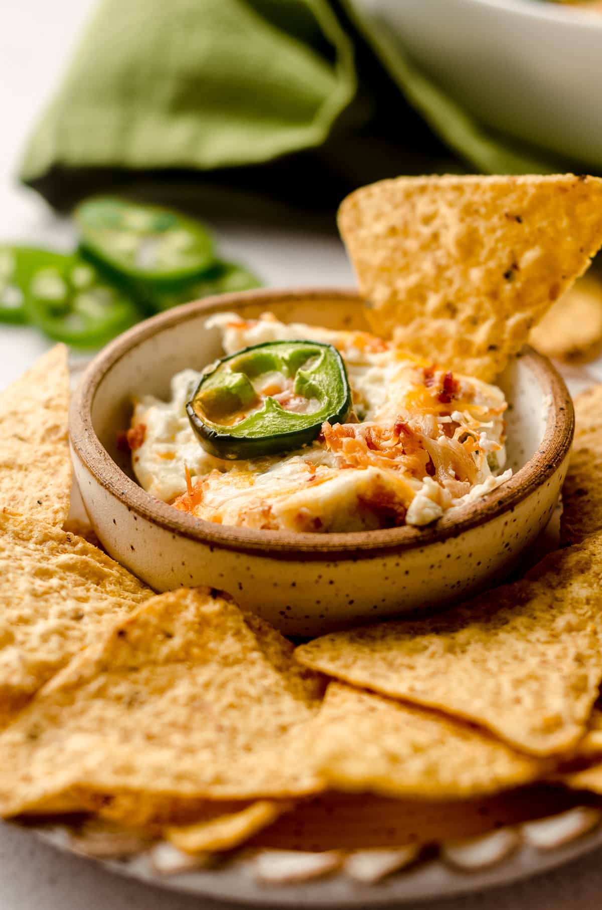 jalapeno cream cheese dip in a bowl on a plate with chips