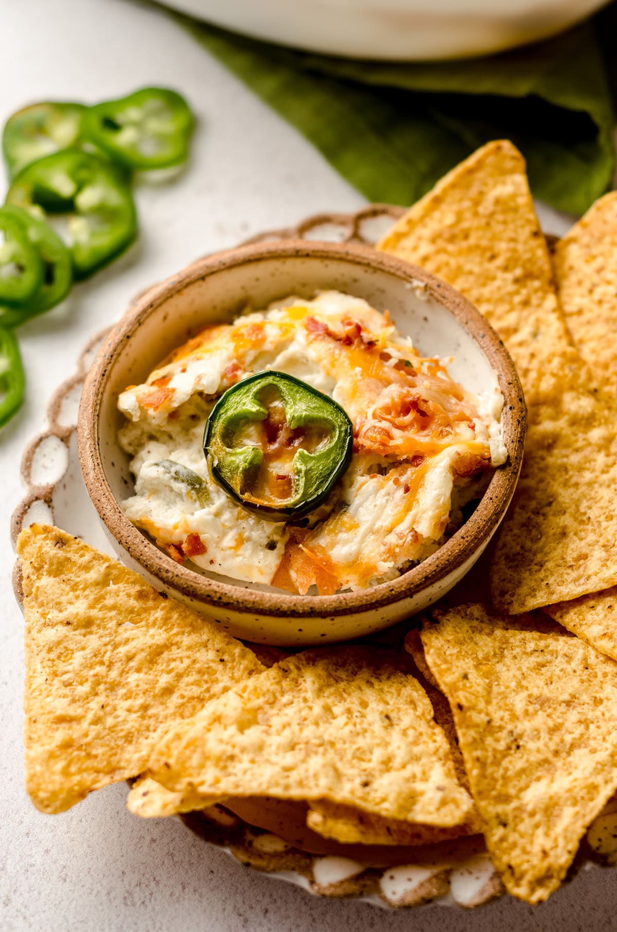 jalapeno cream cheese dip in a bowl on a plate with chips