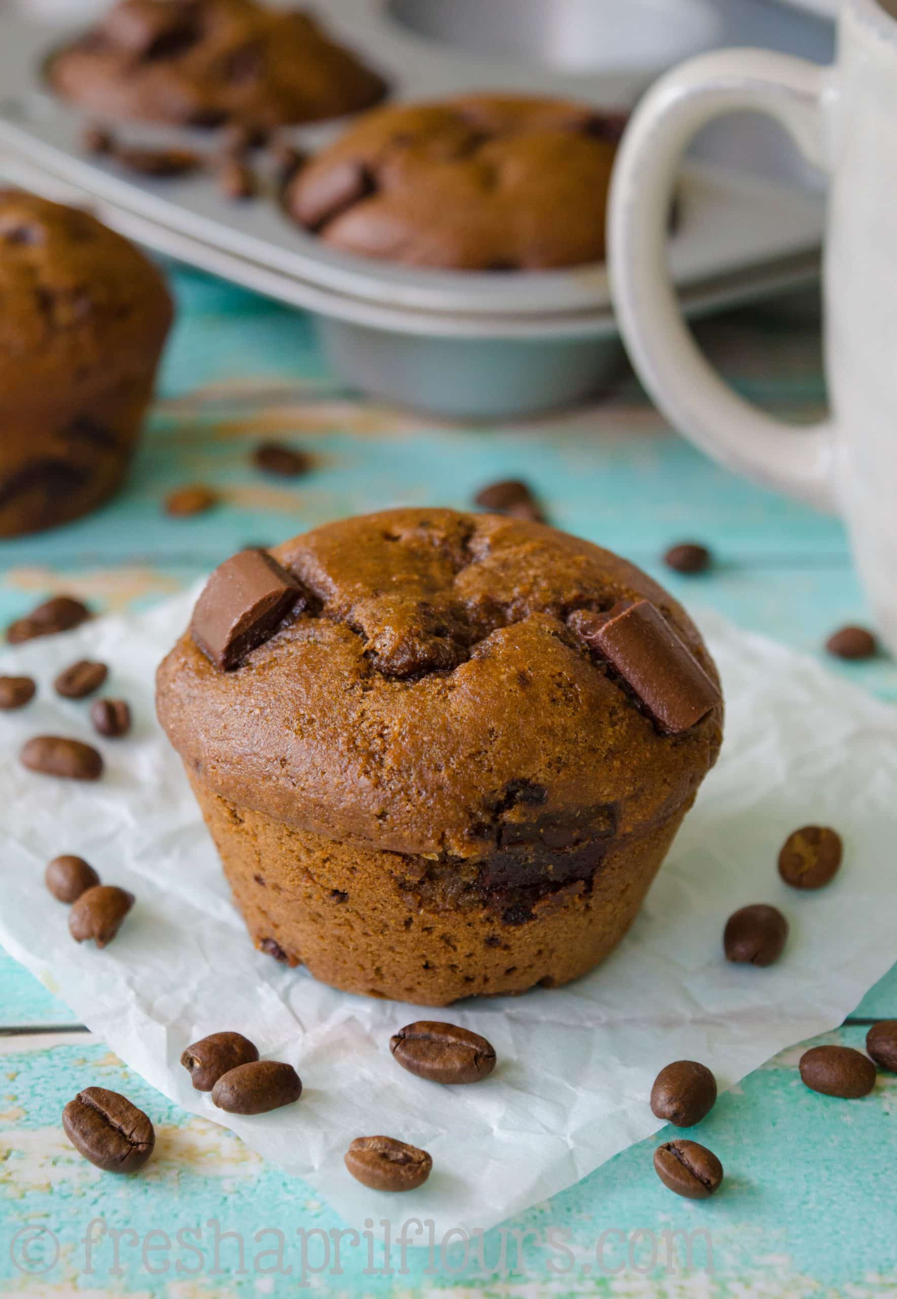 A mocha chocolate chunk muffin on a piece of parchment paper.