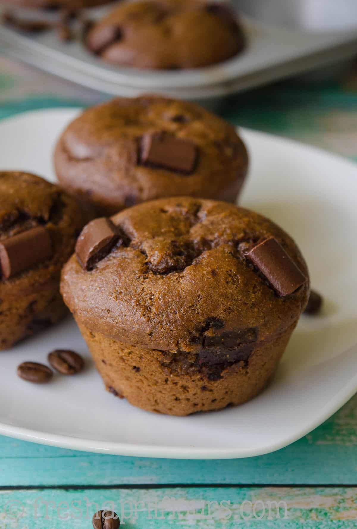 Mocha chocolate chunk muffins on a plate.
