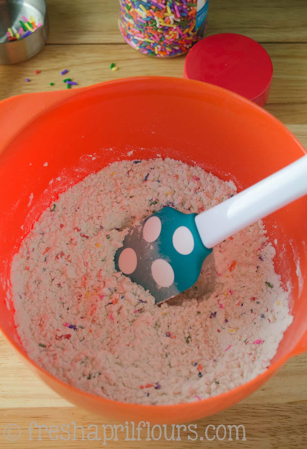 The dry ingredients for funfetti biscotti in a bowl.