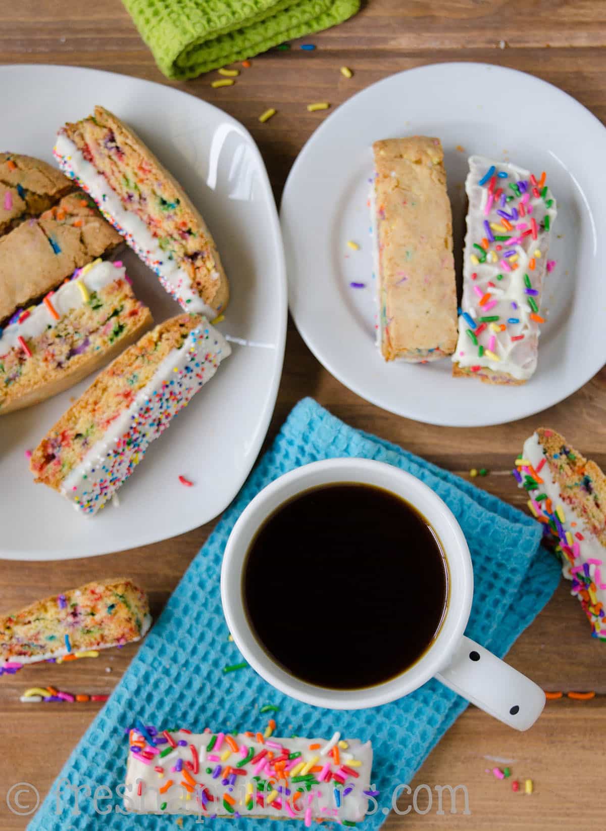 An aerial photo of a cup of coffee and funfetti biscotti.