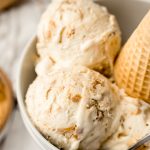 A bowl of peanut butter ripple ice cream with a cone in it.