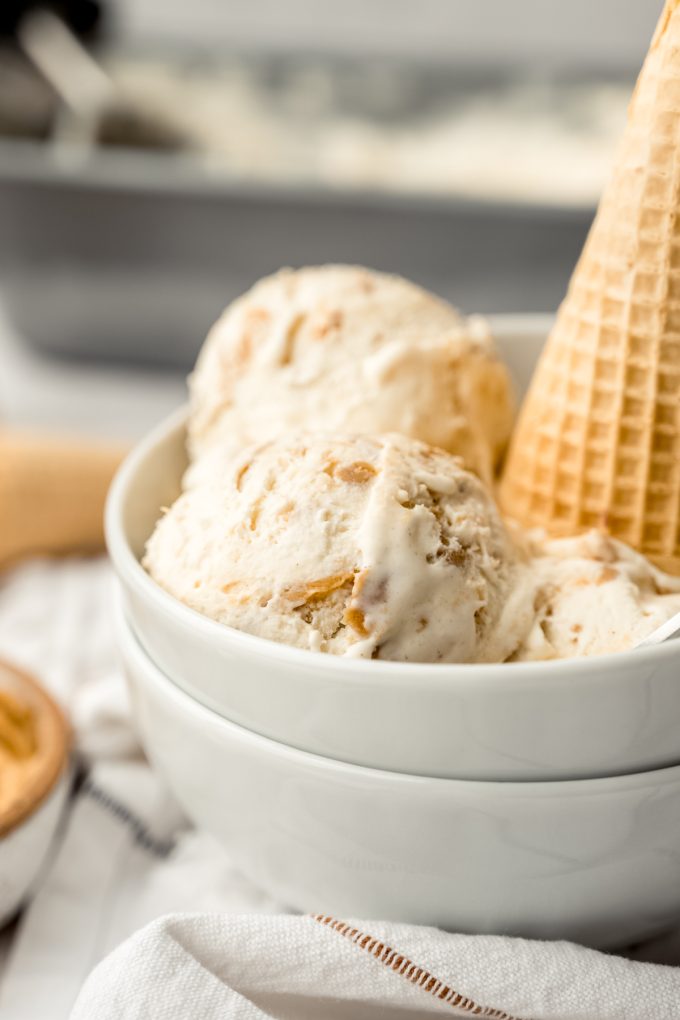A bowl of peanut butter ripple ice cream with a cone in it.