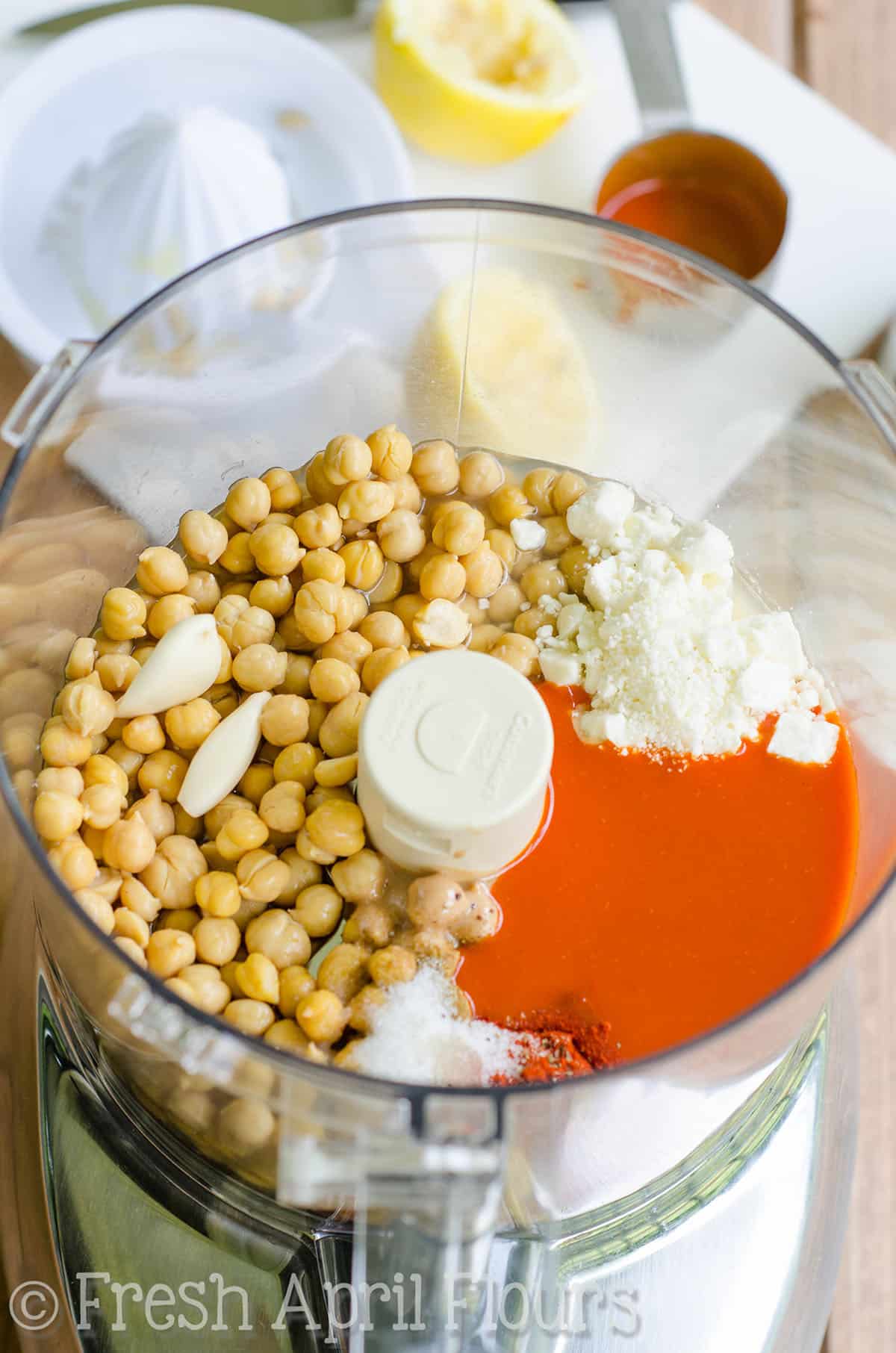 Ingredients for buffalo hummus in a food processor ready to blend.