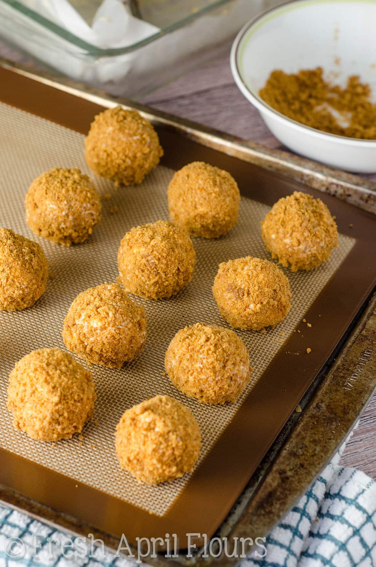 Gingersnap cheesecake bites on a baking sheet.