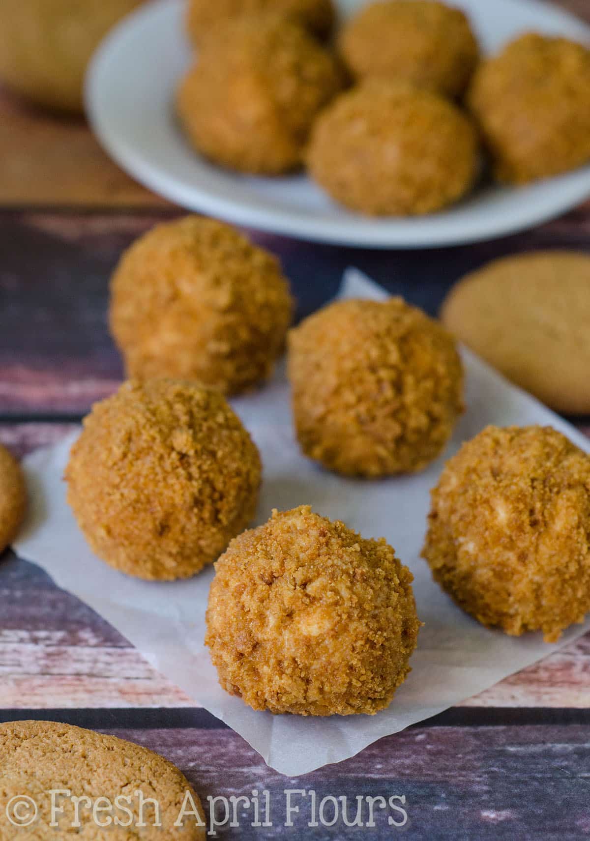 Gingersnap cheesecake bites on a piece of parchment paper.