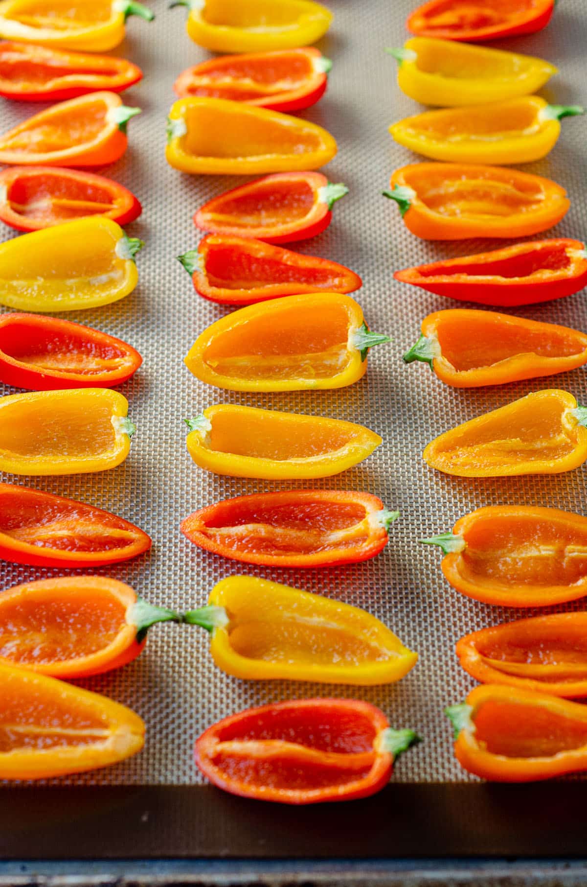 mini bell peppers on a baking sheet ready to stuff with filling