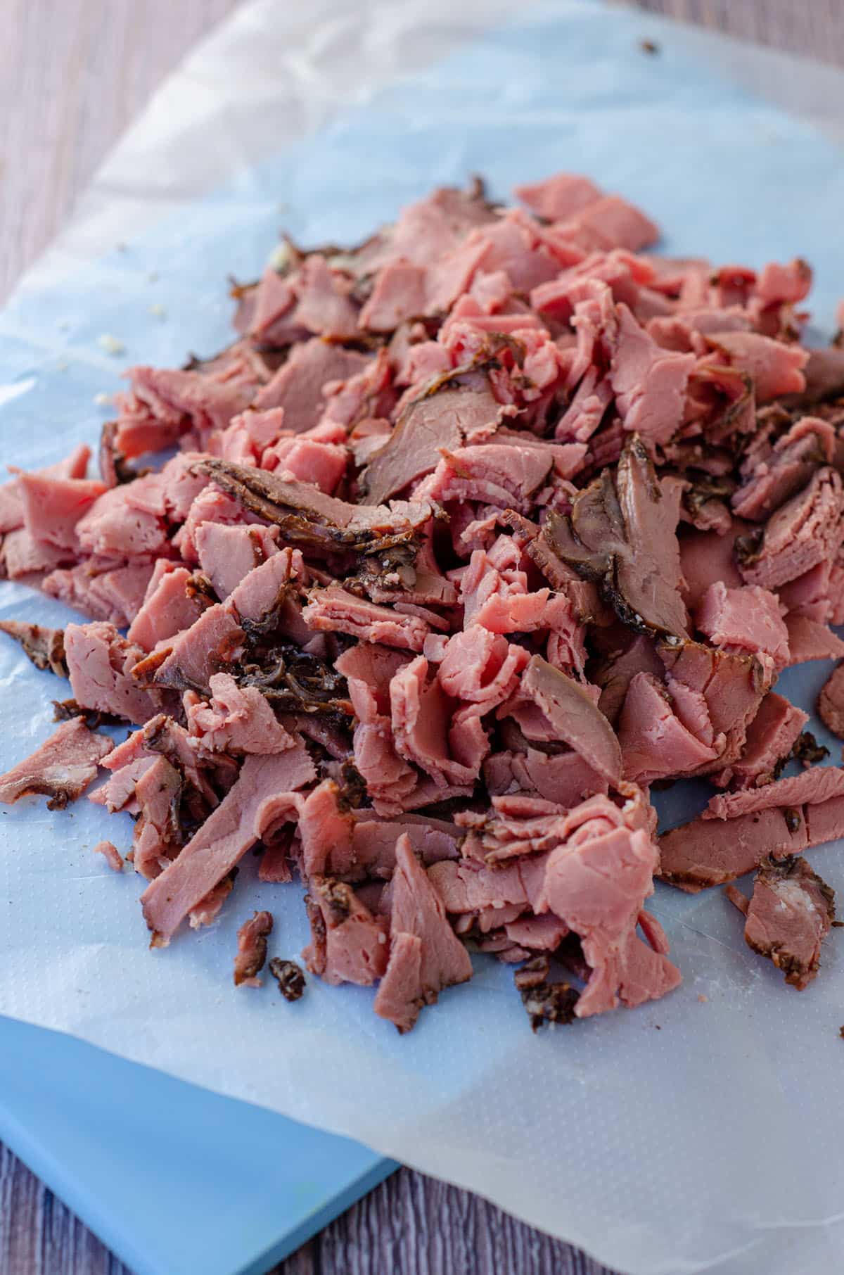 shredded roast beef on a blue cutting board