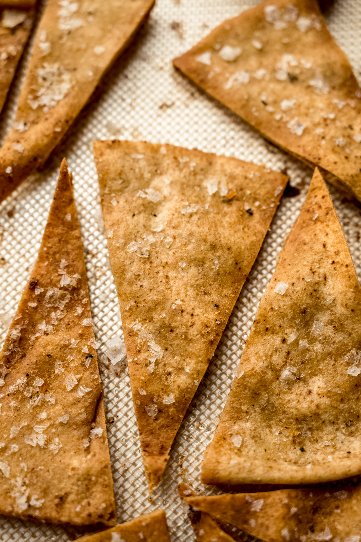 Homemade pita chips on a baking sheet.