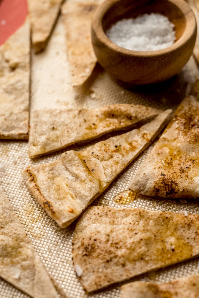 Homemade pita chips on a baking sheet before being baked.