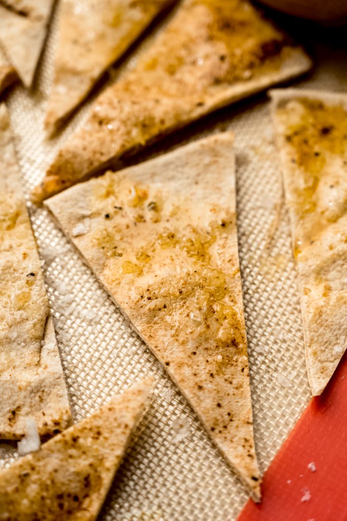 Homemade pita chips on a baking sheet before being baked.