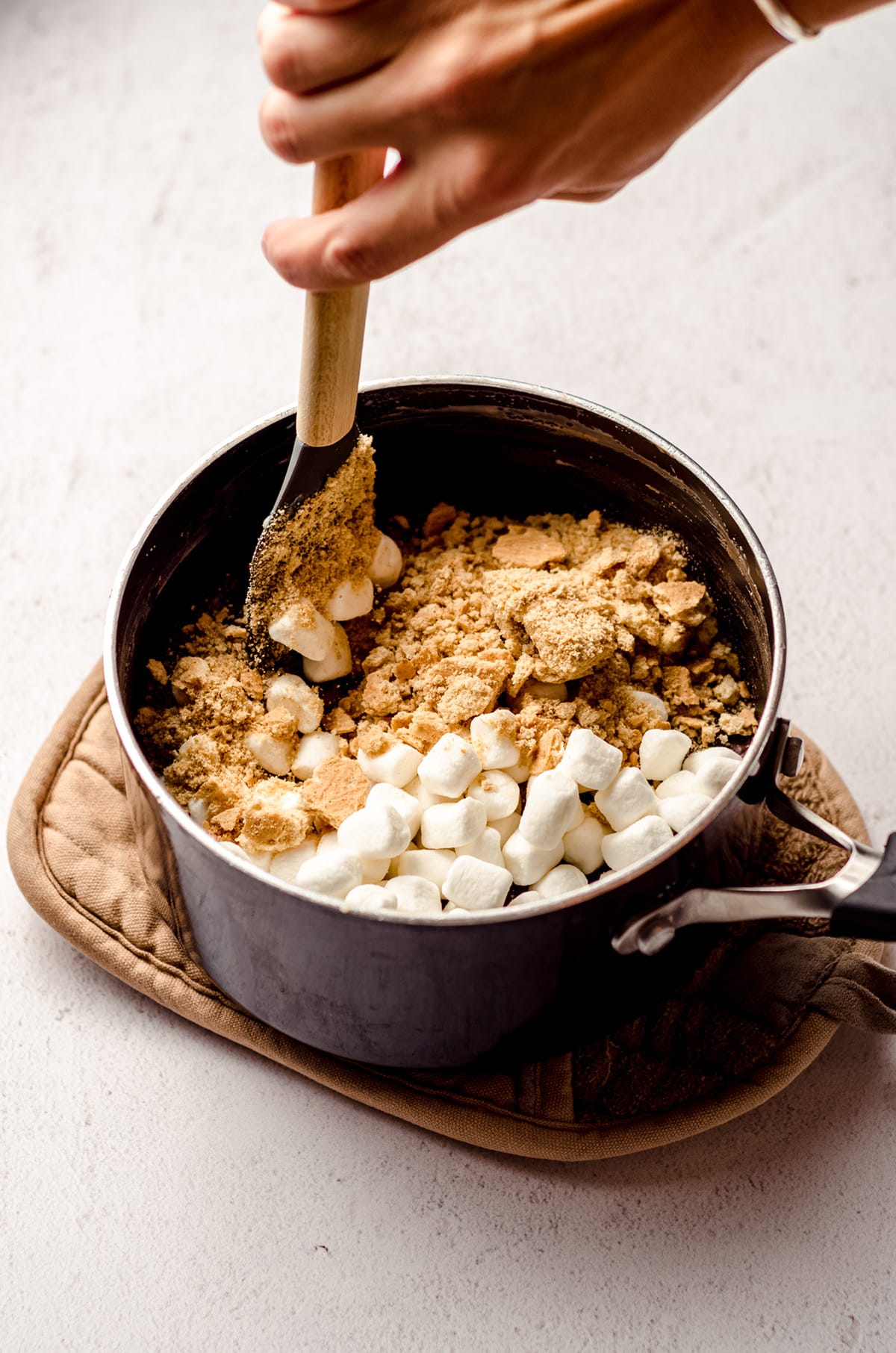 stirring ingredients for s'mores fudge in a saucepan