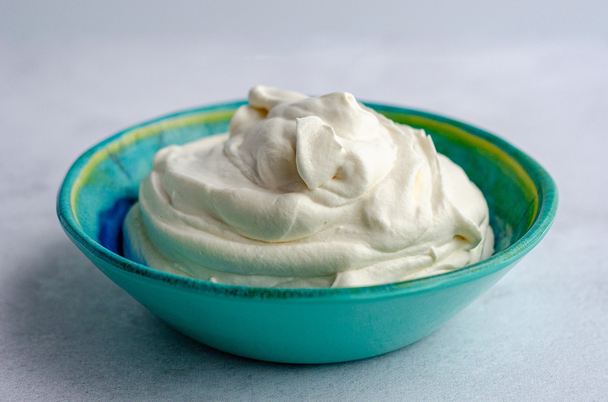 homemade whipped cream in a blue and green bowl