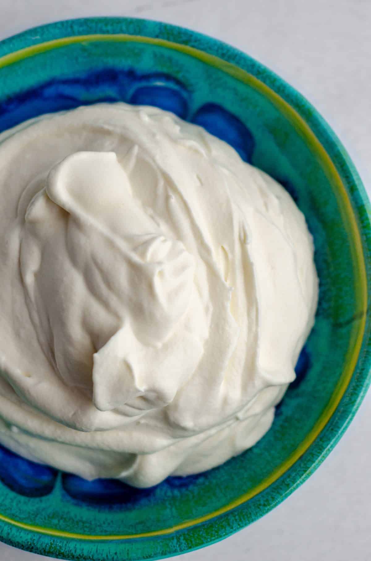 homemade whipped cream in a blue and green bowl