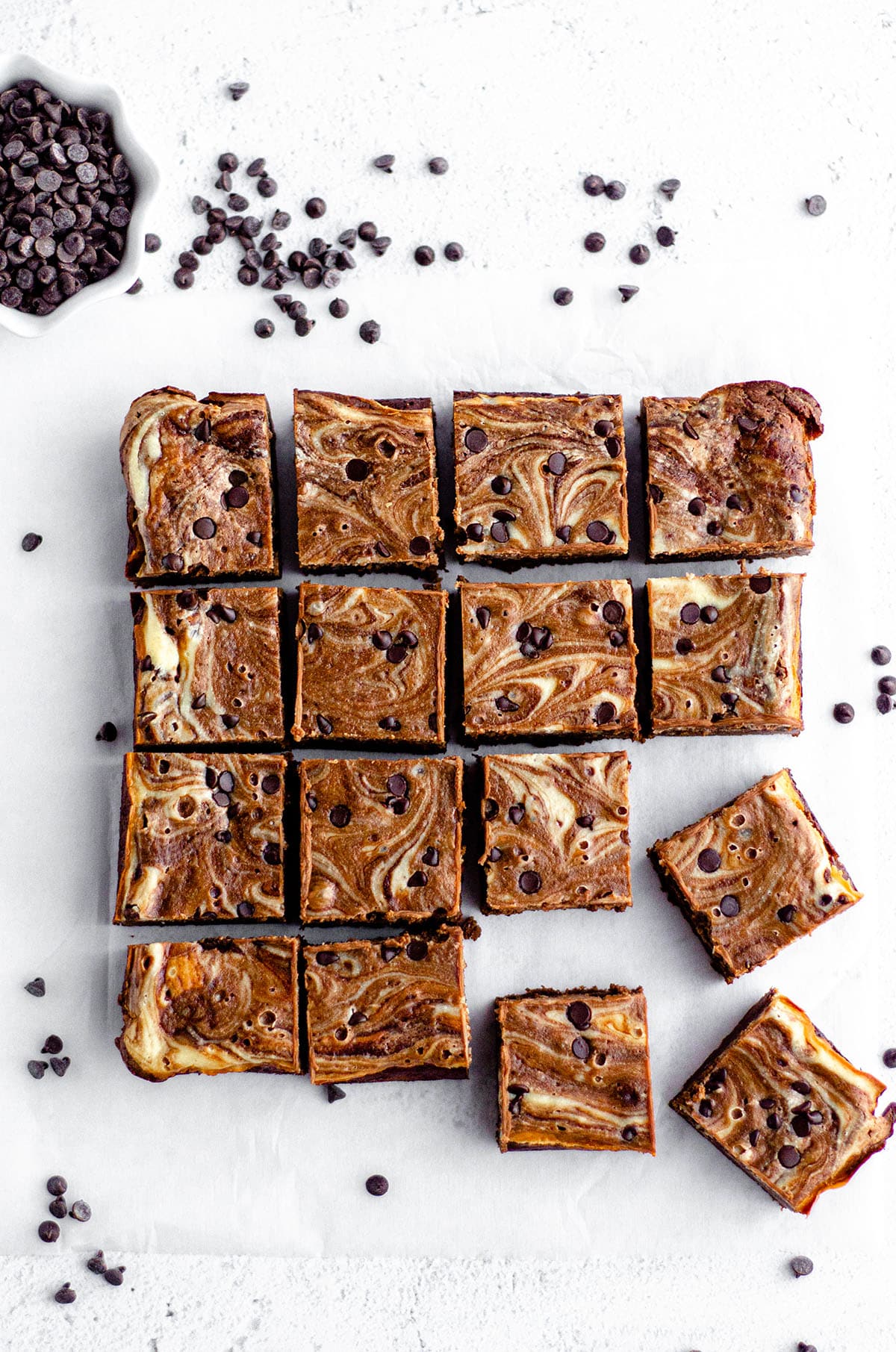 aerial photo of cut brownies in a group with a small bowl of mini chocolate chips