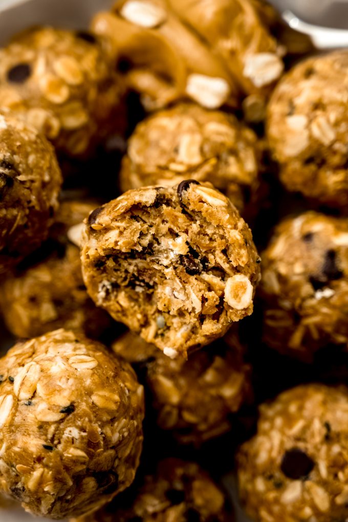 A bowl of chocolate chip oat bites and the one on the top has a bite taken out of it.