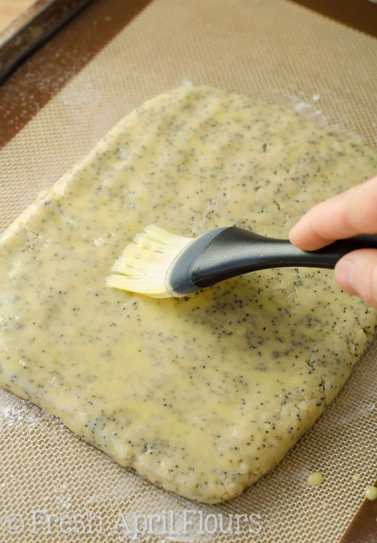 brushing lemon poppy seed biscotti dough with an egg wash