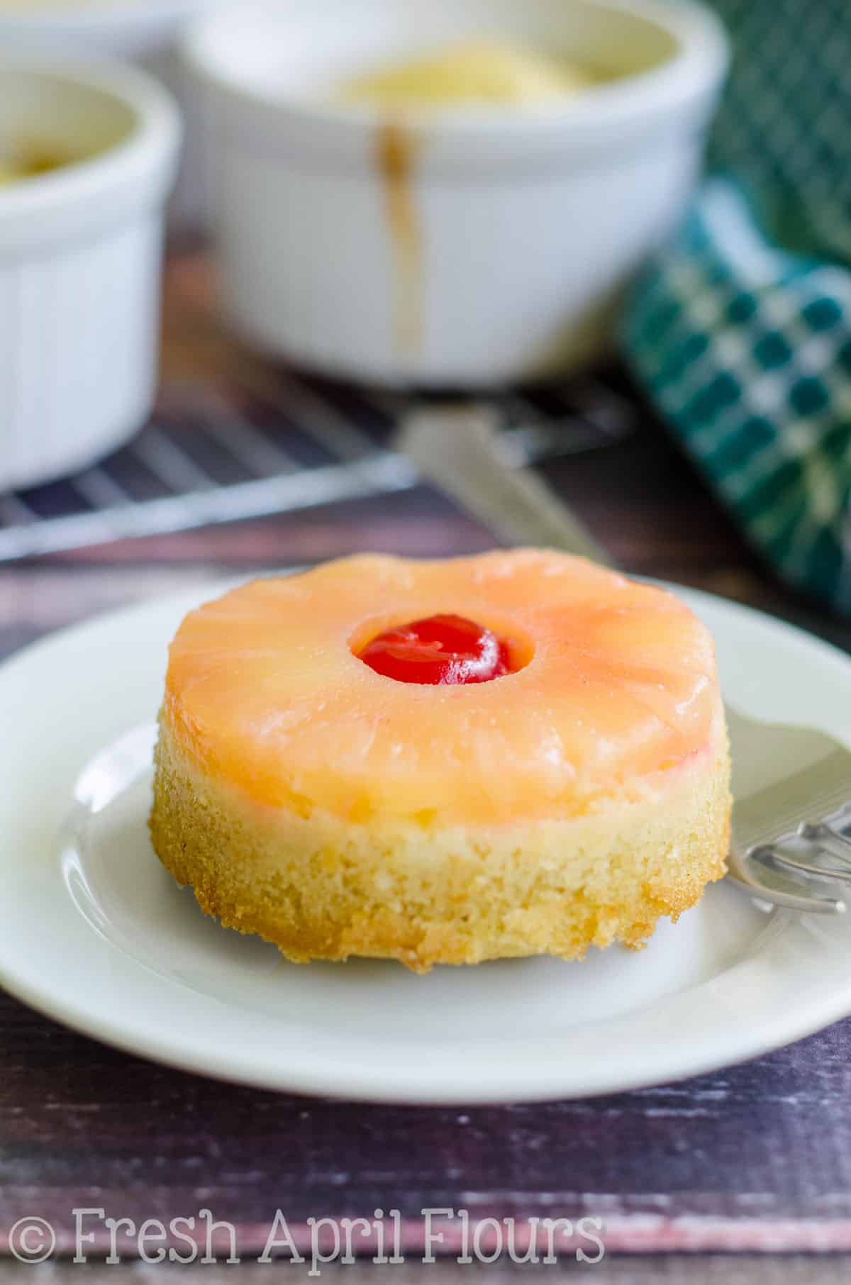 A mini pineapple upside down cake on a plate with a fork.