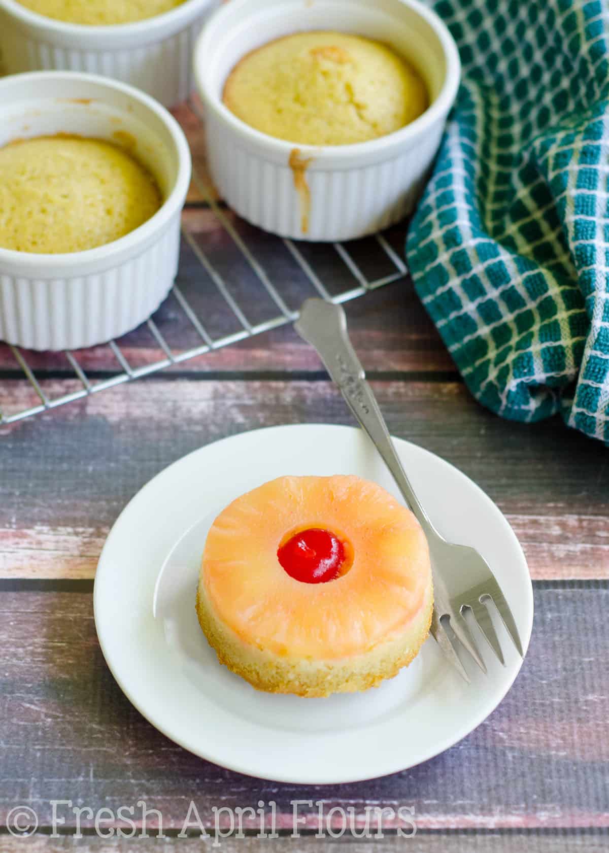 Mini pineapple upside down cake on a plate with a fork.